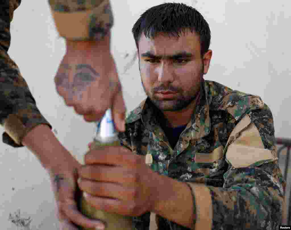 Syria -- A Kurdish fighter from the People's Protection Units (YPG) attaches a detonator to a rocket in Raqqa, June 15, 2017