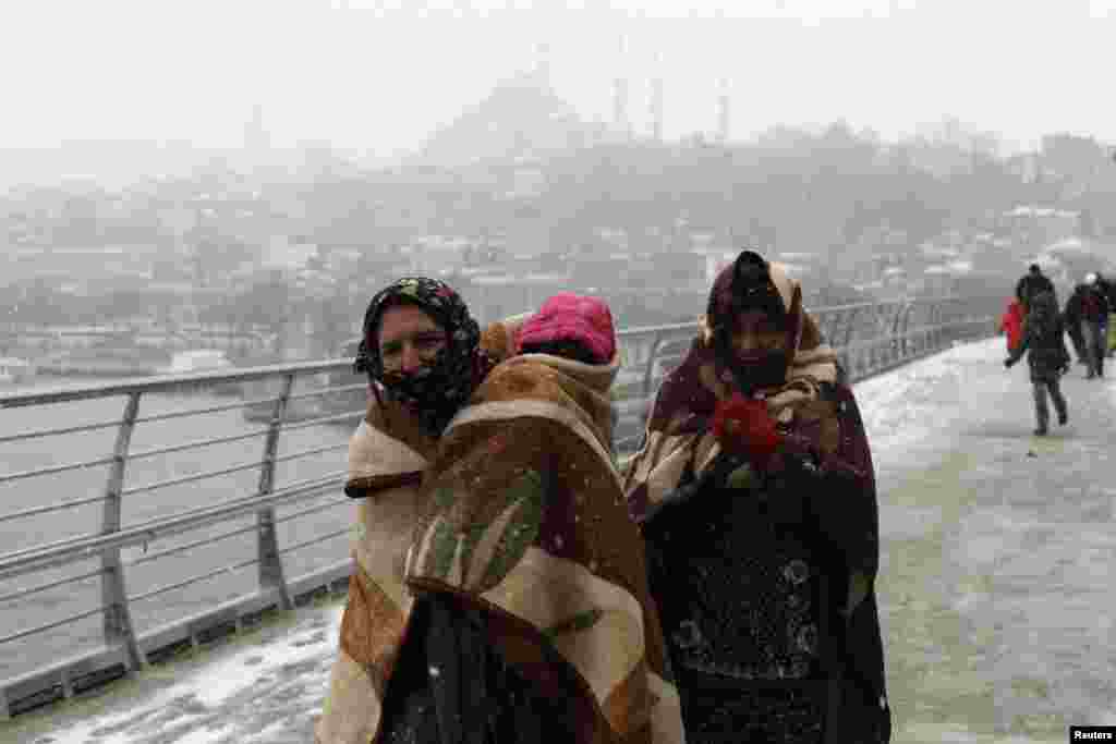 Syrian refugees brave the cold and snow as they walk to a metro station in Istanbul, Turkey, on February 11. (Reuters/​Murad Sezer)