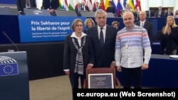 Natalya Kaplan (soldan), Antonio Tajani (ortada) ve Dmitriy Dinze (sağdan) Avropa parlamentinde, 2018 senesi dekabrniñ 12-si