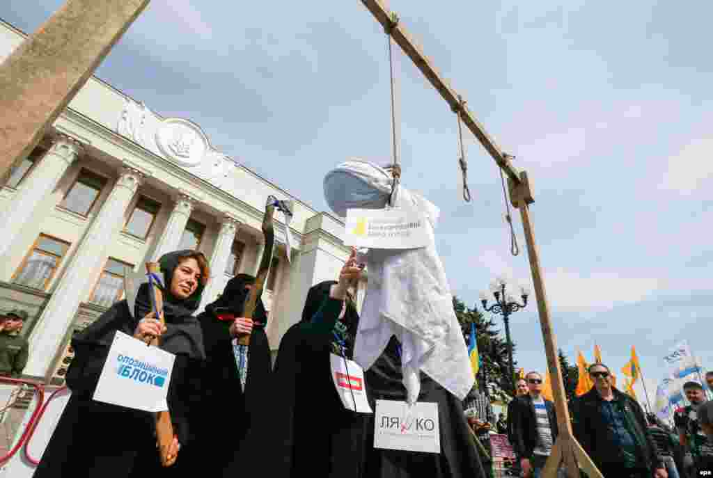 Activists wearing symbolic executioner&#39;s clothes hang an effigy with a sign reading &quot;National Anticorruption Bureau of Ukraine&quot; during a protest at parliament in Kyiv on May 16. (epa/Serhiy Dolzhenko)