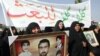 Women carry pictures of relatives killed during Saddam Hussein's regime during a demonstration against the Ba'ath Party in Karbala on January 21.