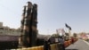 People take a picture next to a Russian-made S-300 air defense system displayed on Baharestan square in Tehran, September 24, 2017