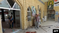 Men clean up after a bomb detonated at a Shi'ite mosque in the northern city of Kirkuk on April 19.