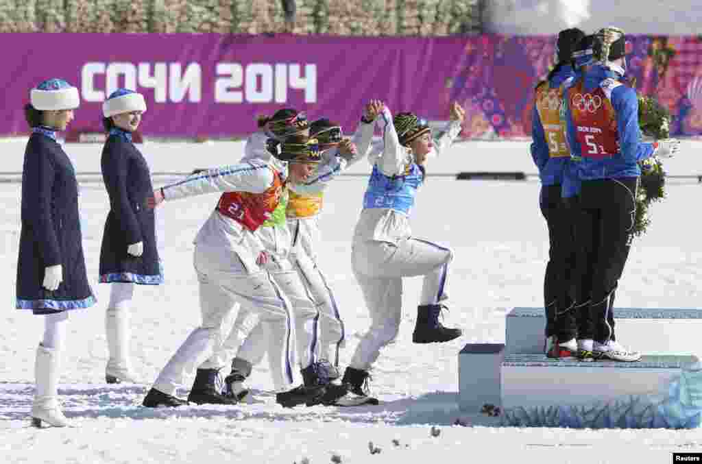 Sweden&#39;s relay team, Ida Ingemarsdotter, Emma Wiken, Anna Haag, and Charlotte Kalla, celebrate during the flower ceremony for the women&#39;s cross-country 4 x 5km relay event. The Swedish team won gold. (REUTERS/Sergei Karpukhin)