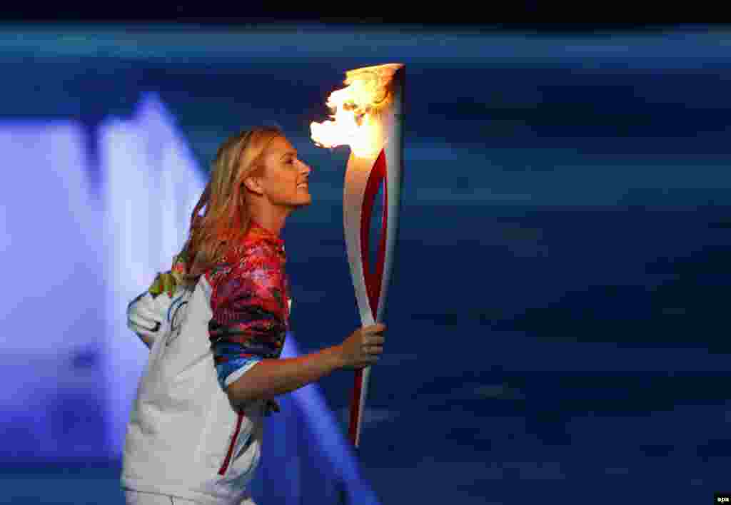 Russian tennis star Maria Sharapova carries the Olympic flame.&nbsp;