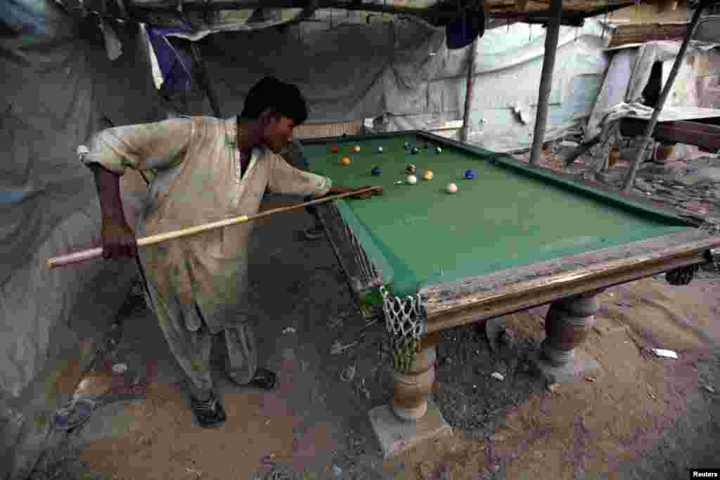 A boy plays billiards on the outskirts of Karachi, Pakistan. (Reuters/Athar Hussain)