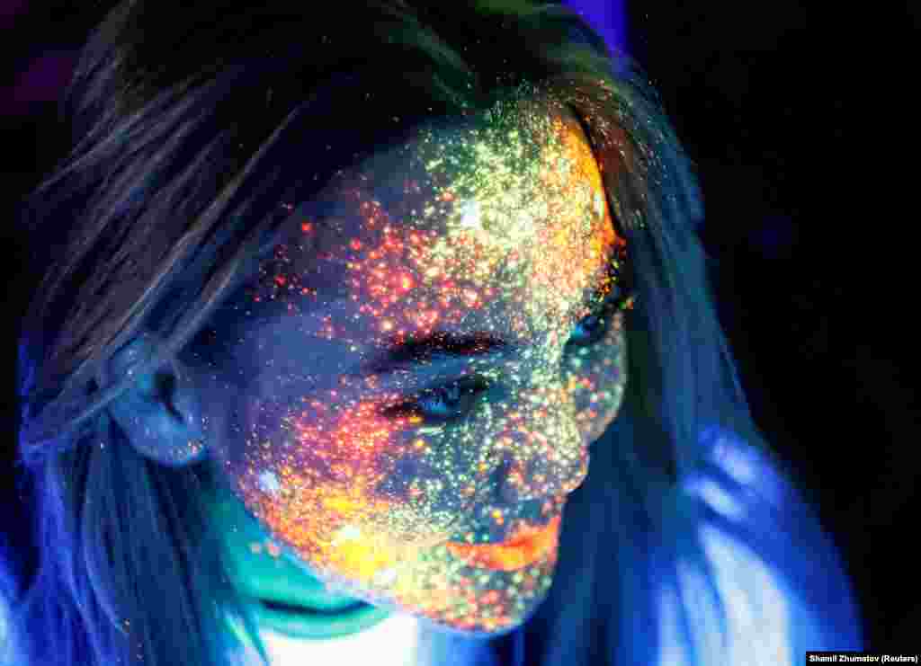 A participant with her face decorated with fluorescent paint smiles before the YARKOcross Night Edition color race in Almaty, Kazakhstan, on September 15. (Reuters/Shamil Zhumatov)