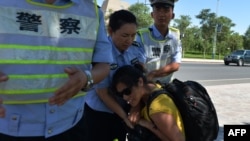 Китайские полицейские забирают фотоаппарат у журналиста в городе Луккун в Синьзяне. 28 июня 2013 года. Иллюстративное фото. 