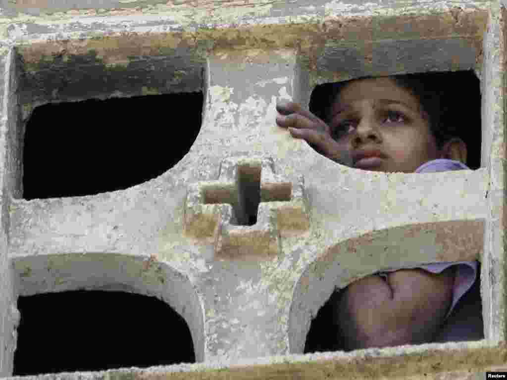 A Christian boy lookson May 8 from inside the St. Mary Church, which was set on fire during clashes between Muslims and Christians on May 7, in the heavily populated area of Imbaba in Cairo. Egypt's prime minister called an emergency cabinet meeting after 10 people died in bloody clashes in a Cairo suburb over the conversion of a Christian woman to Islam. Photo by Mohamed Abd El-Ghany for Reuters