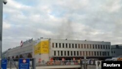 Black smoke is seen rising from the Brussels airport following explosions on March 22.