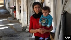 Жінка з дитиною з громади язидів, що втекла від насильства бойовиків угруповання «Ісламська держава» з міста Синджар і знайшла притулок у таборі для переміщених осіб
