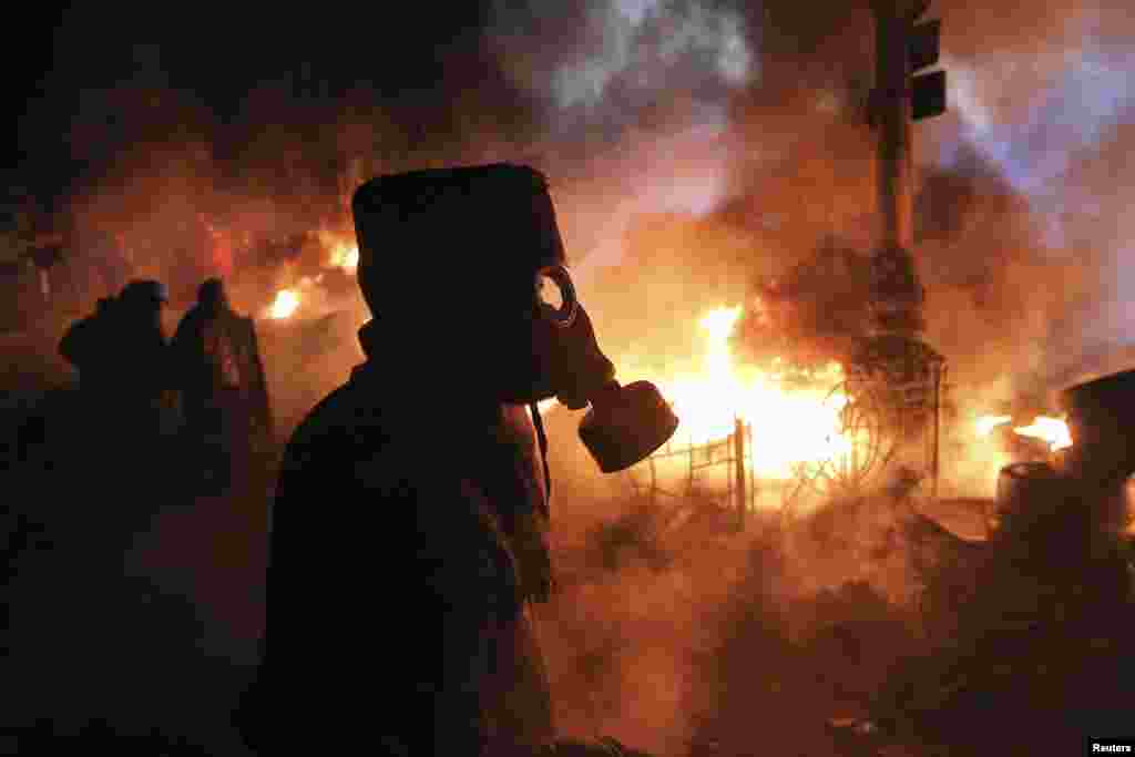 Antigovernment protesters gather at a barricade at the site of earlier clashes with riot police in Kyiv.