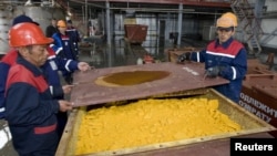Рабочие грузят оксид урана на предприятии "Казатомпрома" на юге Казахстана.