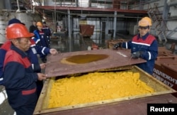 Жұмысшылар уран тотығы салынған контейнерді жауып жатыр. Оңтүстік Қазақстан облысы, Хорасан-1 уран кеніші, 24 сәуір 2009 жыл.
