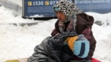 A young woman with her child begs amid heavy snow at a market in the Kyrgyz capital, Bishkek. (file photo)