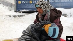 A young woman with her child begs amid heavy snow at a market in the Kyrgyz capital, Bishkek. (file photo)