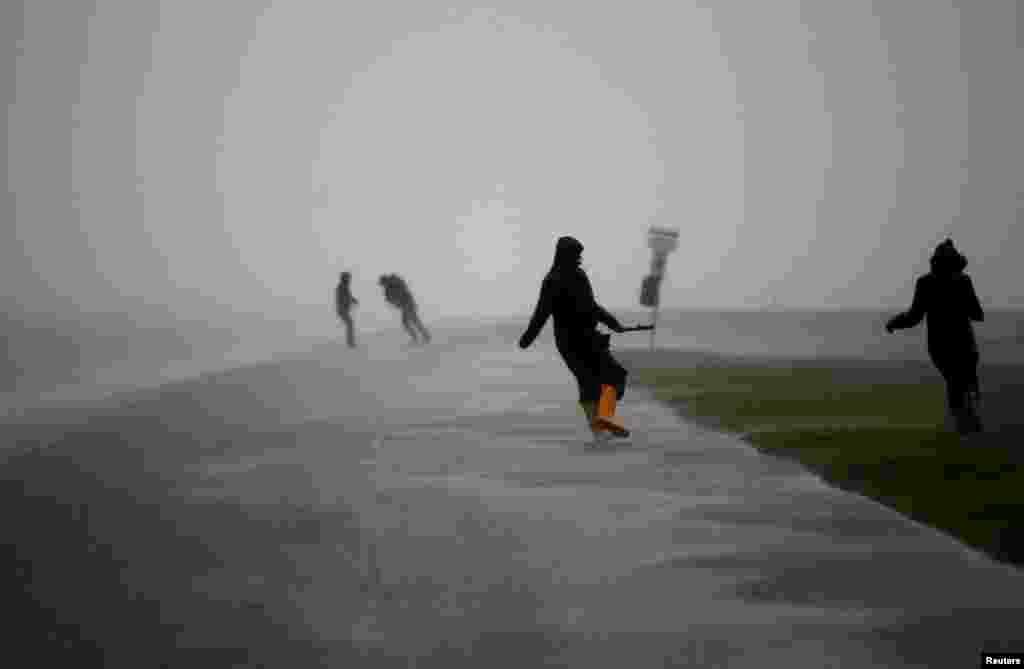 People walk on the North Sea beach near the German town of Norddeich. Germany's northern coast has been battered by a storm called "Xaver," which has brought strong winds and high tides to the region. (Reuters/Ina Fassbender) 
