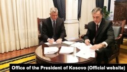 Presidenti i Kosovës, Hashim Thaçi dhe ai i Malit të Zi, Filip Vujanoviq, duke nënshkruar deklaratën e përbashkët për Demarkacionin 