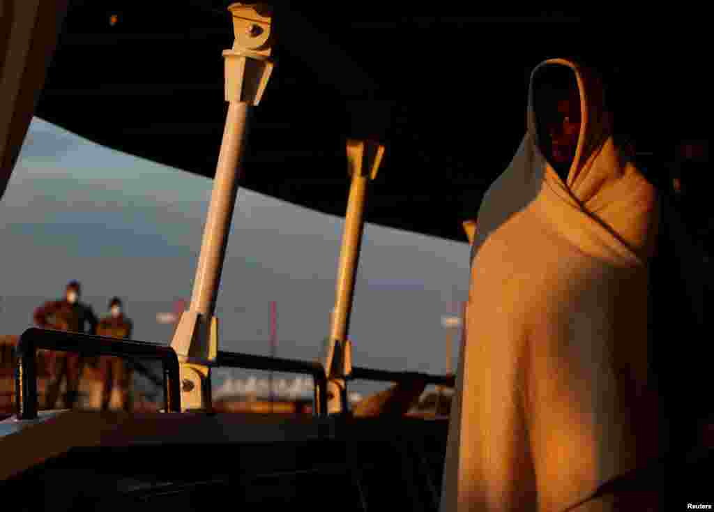 A rescued migrant waits to disembark from the Malta-based NGO Migrant Offshore Aid Station ship Phoenix in Pozzallo on the island of Sicily, Italy. (Reuters/Darrin Zammit Lupi)