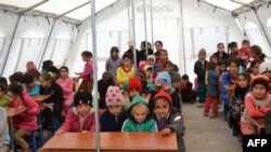 أطفال عراقيون يجلسون بمدرسة مؤقتة في مخيم للنازحين التركمان الفارّين من تلعفر