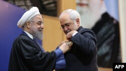 Iranian President Hassan Rohani (left) presents Foreign Minister Mohammad Javad Zarif with a Medal of Honor for his role in the implementation of a nuclear deal with world powers, in Tehran on February 16.