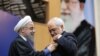 حسن روحانی در حال اعطای مدال به محمد جواد ظریف و تقدیر از خدمت او در جریان توافق هسته ای.