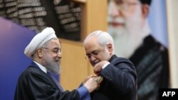 حسن روحانی در حال اعطای مدال به محمد جواد ظریف و تقدیر از خدمت او در جریان توافق هسته ای.