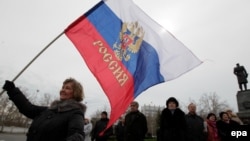 A woman holds a Russian flag on a central square in Sevastopol, the Crimean capital, on March 16.