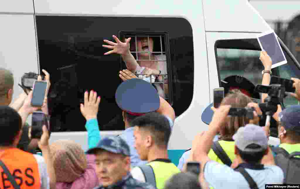 A woman reacts inside a police minibus after she was detained during a protest rally held by Kazakh opposition supporters in Almaty on July 6. (Reuters/Pavel Mikheyev)