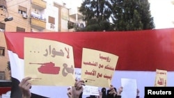 Antigovernment demonstrators march through the streets of Homs earlier this month.