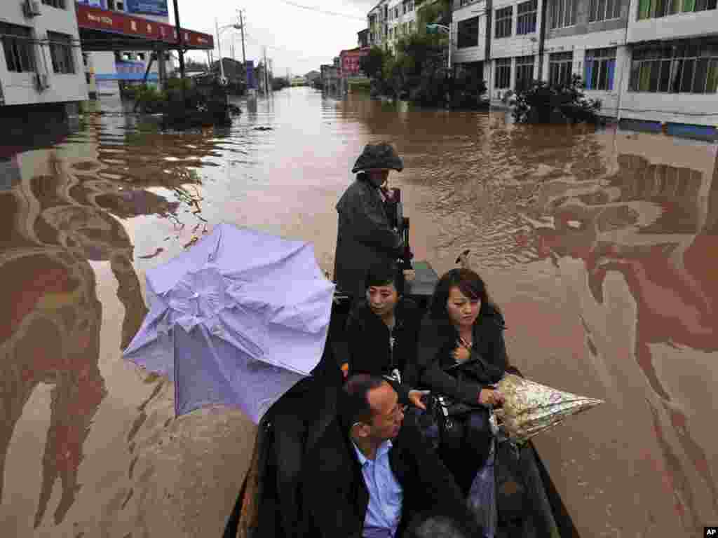 Rezidenți ai regiunii Dazhou eveacuați dintr-o zonă inundată &icirc;n sud-vestul Chinei. (Photo: AP)