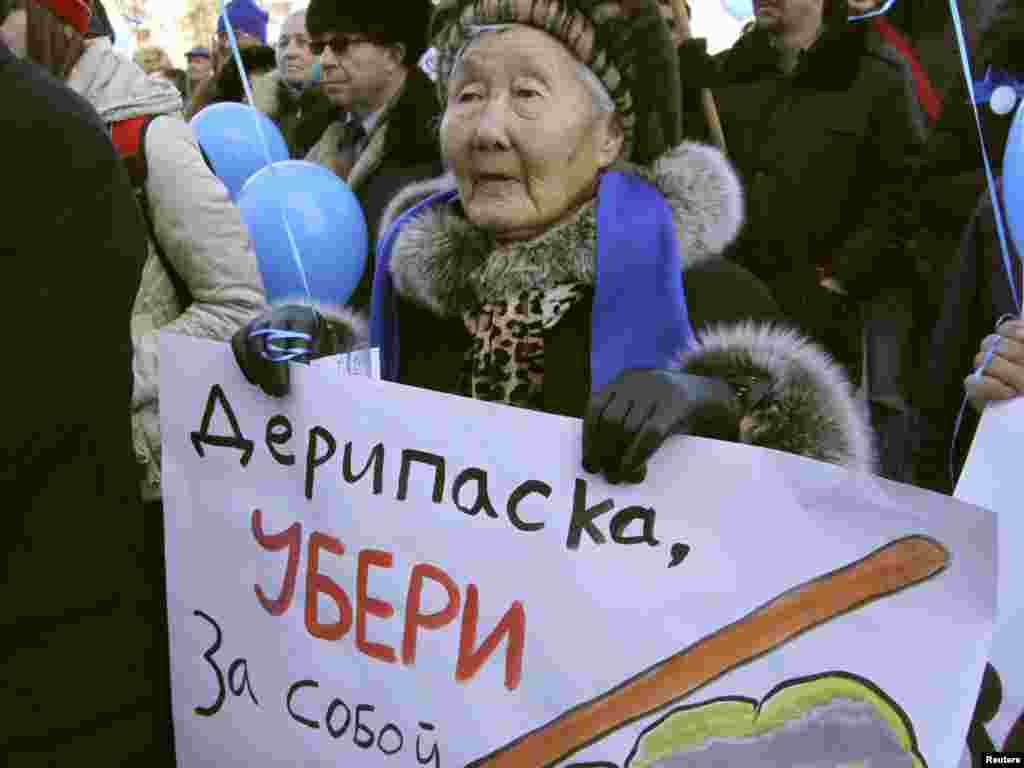 A woman protests in Irkutsk. - The poster reads, "Deripaska, Clean Up After Yourself." Oligarch Oleg Deripaska owns the paper mill, which will dump waste into the lake.