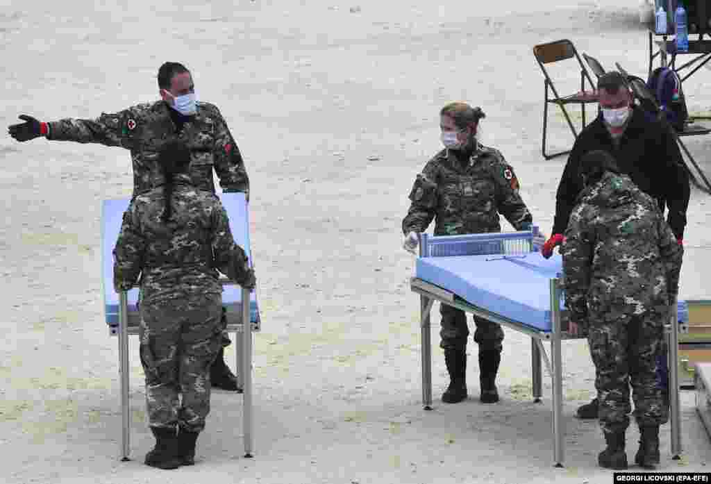 Македонски војници поставуваат кревети за новата мобилна болница веднаш до Универзитетската клиника за инфективни болести во Скопје на 31 март.