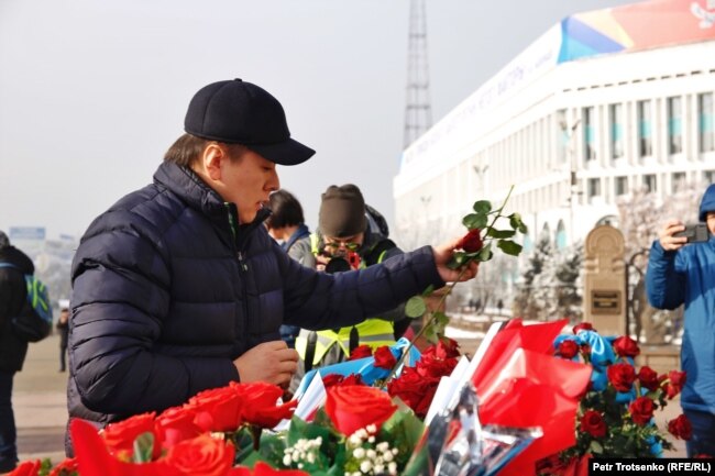 Активист Жанболат Мамай возлагает цветы к монументу Независимости в Алматы. 16 декабря 2019 года.