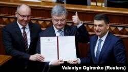 Зліва направо: спікер парламенту Андрій Парубій, президент Петро Порошенко і прем’єр-міністр Володимир Гроймсан на трибуні Верховної Ради з підписаним главою держави законом про зміни до Конституції, які закріплюють курс України на ЄС і НАТО. Київ, 19 лютого 2019 року