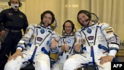 Canadian astronaut Robert Thirsk (left), Russian cosmonaut Roman Romanenko, and Belgian astronaut Frank de Winne during preparations before their flight
