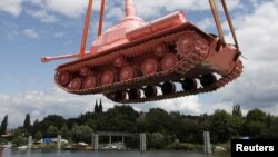 Окрашенный в розовый цвет советский танк грузят на судно, чтобы доставить в Прагу. 20 июня 2011 года.