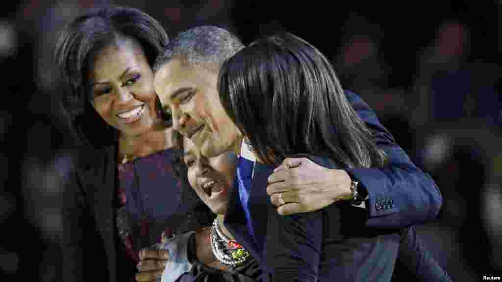 President Barack Obama hugs his daughters Malia and Sasha as First Lady Michelle Obama looks on during his election night victory rally in Chicago.