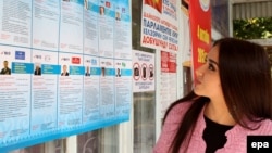 A Kyrgyz woman reads information about the candidates for parliament at a polling station in the town of Belovodsk, in Kyrgyzstan's Chui Province.