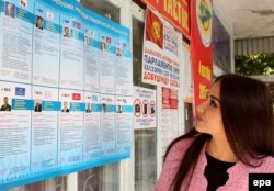 A voter reads information about the candidates for parliament at a polling station in the town of Belovodsk on September 30.