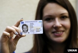 Дівчина тримає паспорти громадянки України у формі ID-картки. Ілюстративне фото