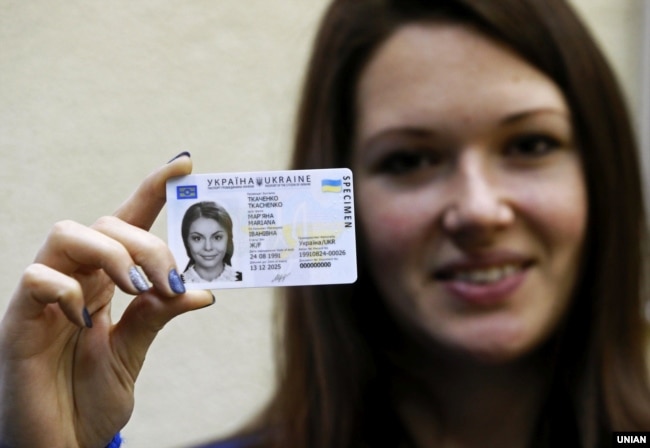 Дівчина тримає паспорти громадянки України у формі ID-картки. Ілюстративне фото
