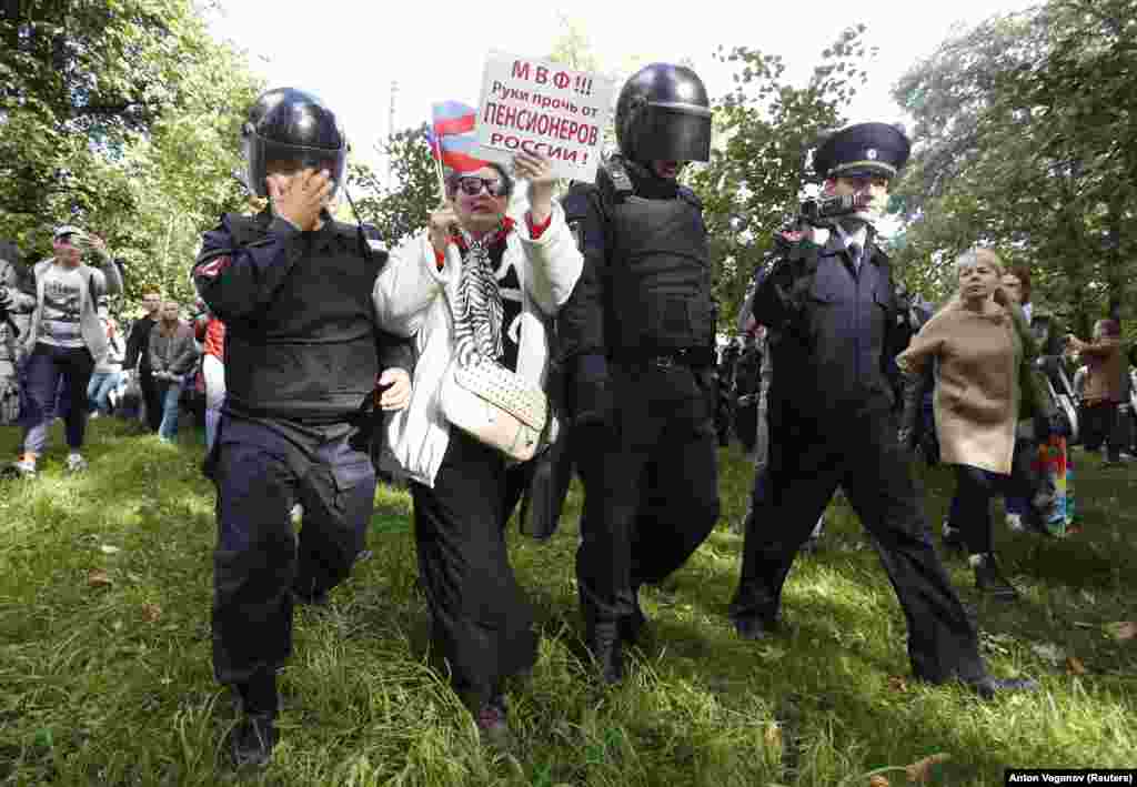 Gözýaşardyjy gazdan gözüne zeper ýeten polisiýa ofiserleri pensiýa reformasyna garşy protest mahalynda protestçini tussag etmäge çalyşýar.&nbsp; St.Peterburg, 16-njy sentýabr. (Reuters/Anton Vaganov)