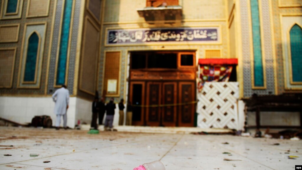 Pakistani security personnel stand guard at a Muslim Sufi shrine where a deadly bomb attack killed more than 80 people, including many children.