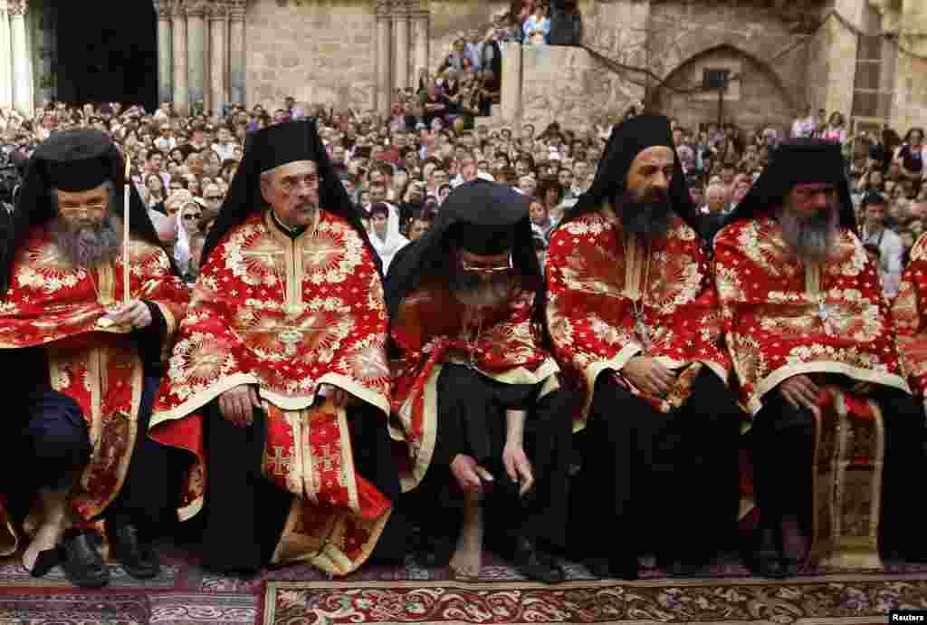 A Greek Orthodox priest puts his shoe back on during the washing of the feet ceremony outside the Church of the Holy Sepulchre in Jerusalem's Old City ahead of Orthodox Easter. (Reuters/Ammar Awad)