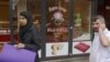 A butcher talks on his mobile phone outside a halal butcher shop in Amsterdam.