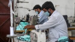 کارگران پاکستانی در حال کار کردن در یک کارخانه تولید پوشاک