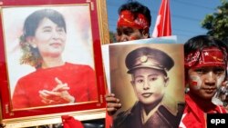 Сторонники Аун Сан Су Чжи держат в руках портреты своего лидера и ее отца, легендарного генерала Аун Сана