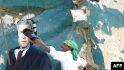 A Shi'ite Muslim uses a slipper to hit the face of an effigy of U.S. President George W. Bush hung in the center of Firdos Square in central Baghdad.