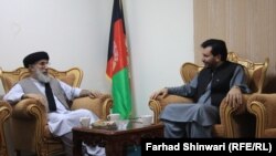 Former Afghan warlord Gulbuddin Hekmatyar (left) speaks to Laghman Province Governor Abdul Jabar Naimi on April 28.